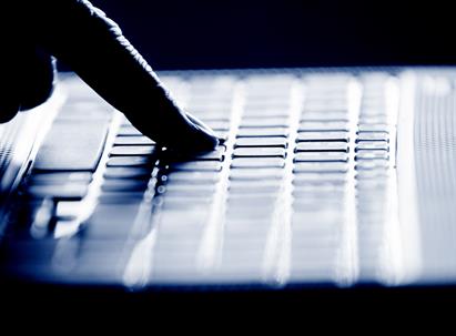 Concept photo in high contrast black and white of hacker's single finger on keyboard