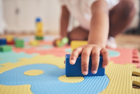 building block in toddler's hand