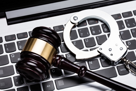 Gavel on computer with handcuffs