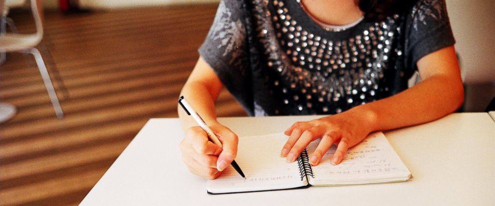 woman writing on her notebook