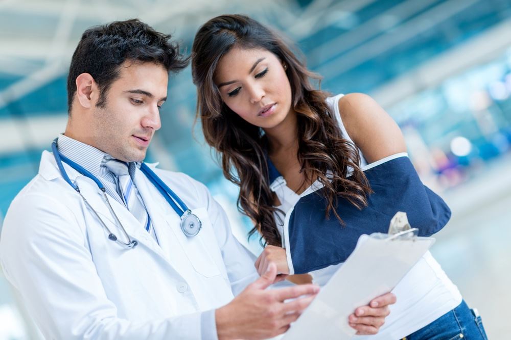 Injured woman at the doctor with a broken arm