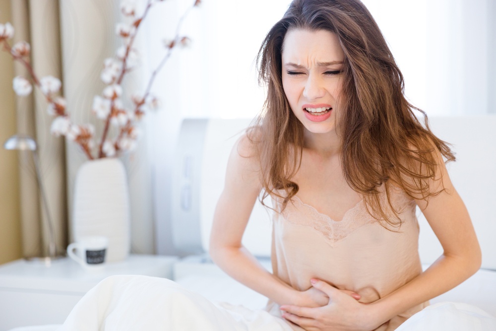 Woman sitting suffering from abdominal pain