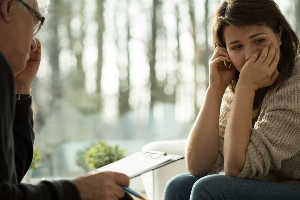 young depressed woman in a window