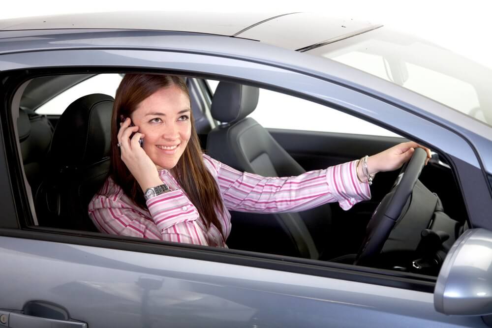 A woman driving a car while on call